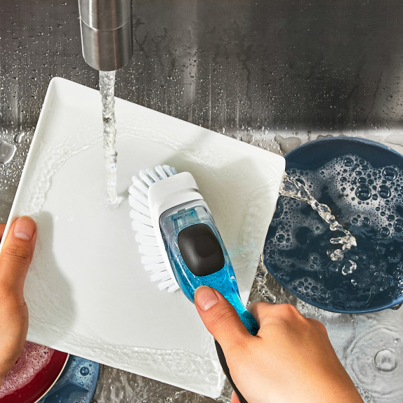 Brosse à manche avec réservoir intégré, idéale pour appliquer des produits de nettoyage ou de soin. Le réservoir est situé dans le manche pour un usage pratique et efficace.